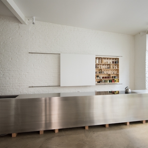 Kubus-förmige Edelstahl-Designküche, fünf Meter langer Monolith auf architektonischen Hölzern stehend