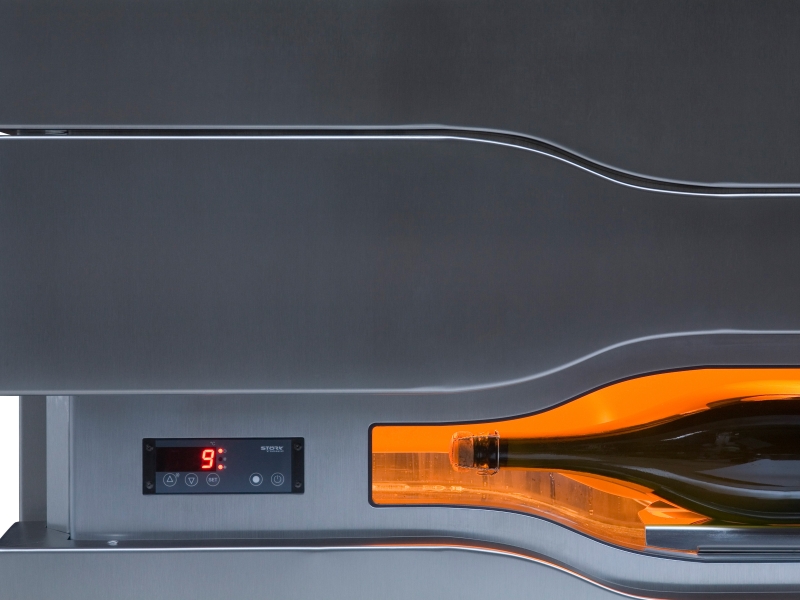 Frontale Aufnahme von geöffnetem Spezial-Designkühlschrank mit Sicht auf beleuchtete Champagnerflasche