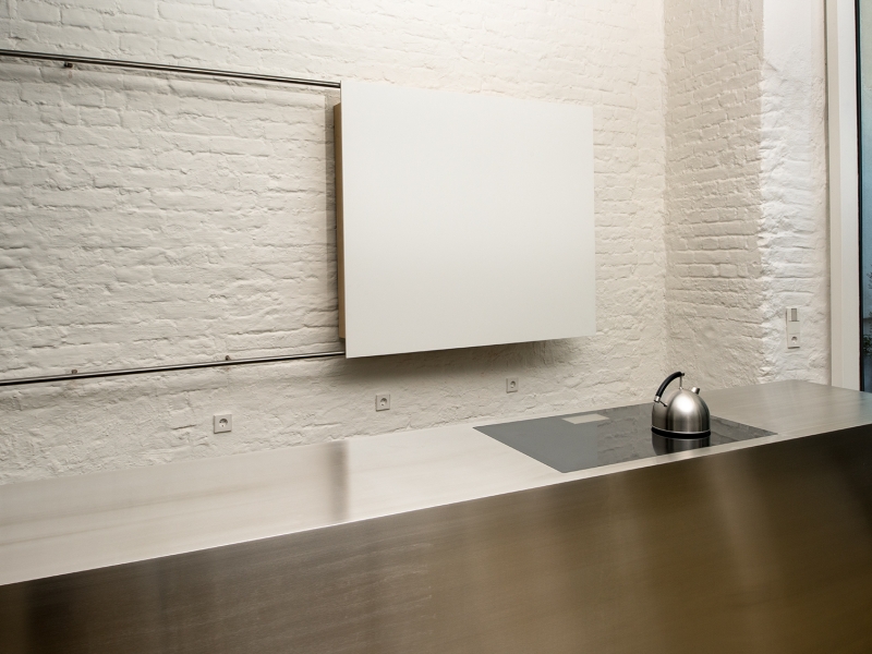 Detail-Aufnahme von flächenbündig integriertem Kochfeld in makellose Edelstahl-Arbeitsfläche (Design)