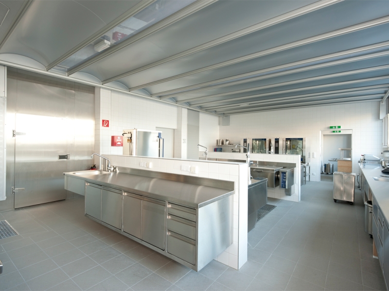 Schulküche/Großküche in Hygiene-Ausführung; Möbel an Wand montiert für einfachste Reinigung im Bodenbereich