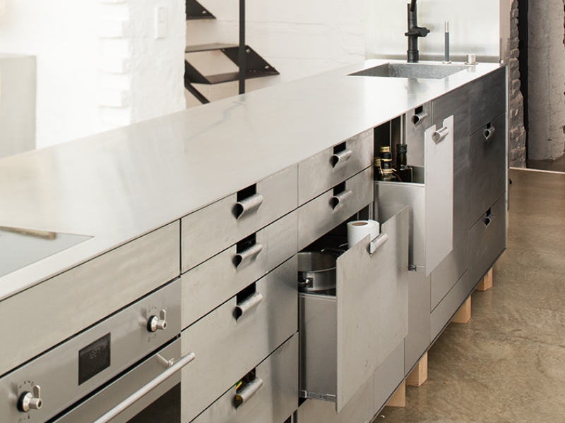 Design-Kochblock in Edelstahl; die Griffe der Laden sind per Hand rund gehämmert