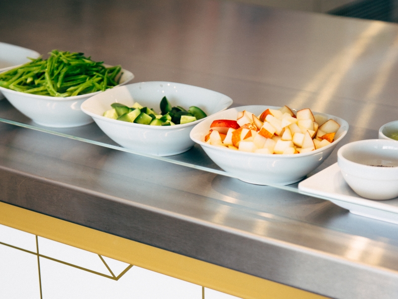 Vorbereitete Zutaten hinter Zugriff-/Spuckschutz aus Glas in Schauküche